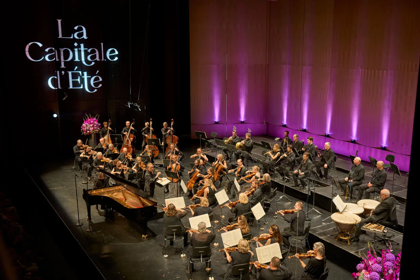 Ein Blick von oben auf das gesamte Orchester auf der Bühne.