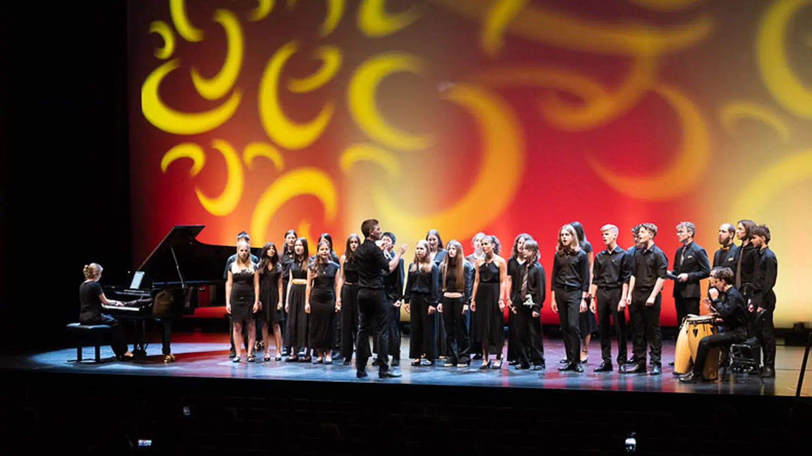 Die Schüler*innen des Projekts IM.PULS stehen auf der Bühne und singen bei dem Abschlusskonzert.