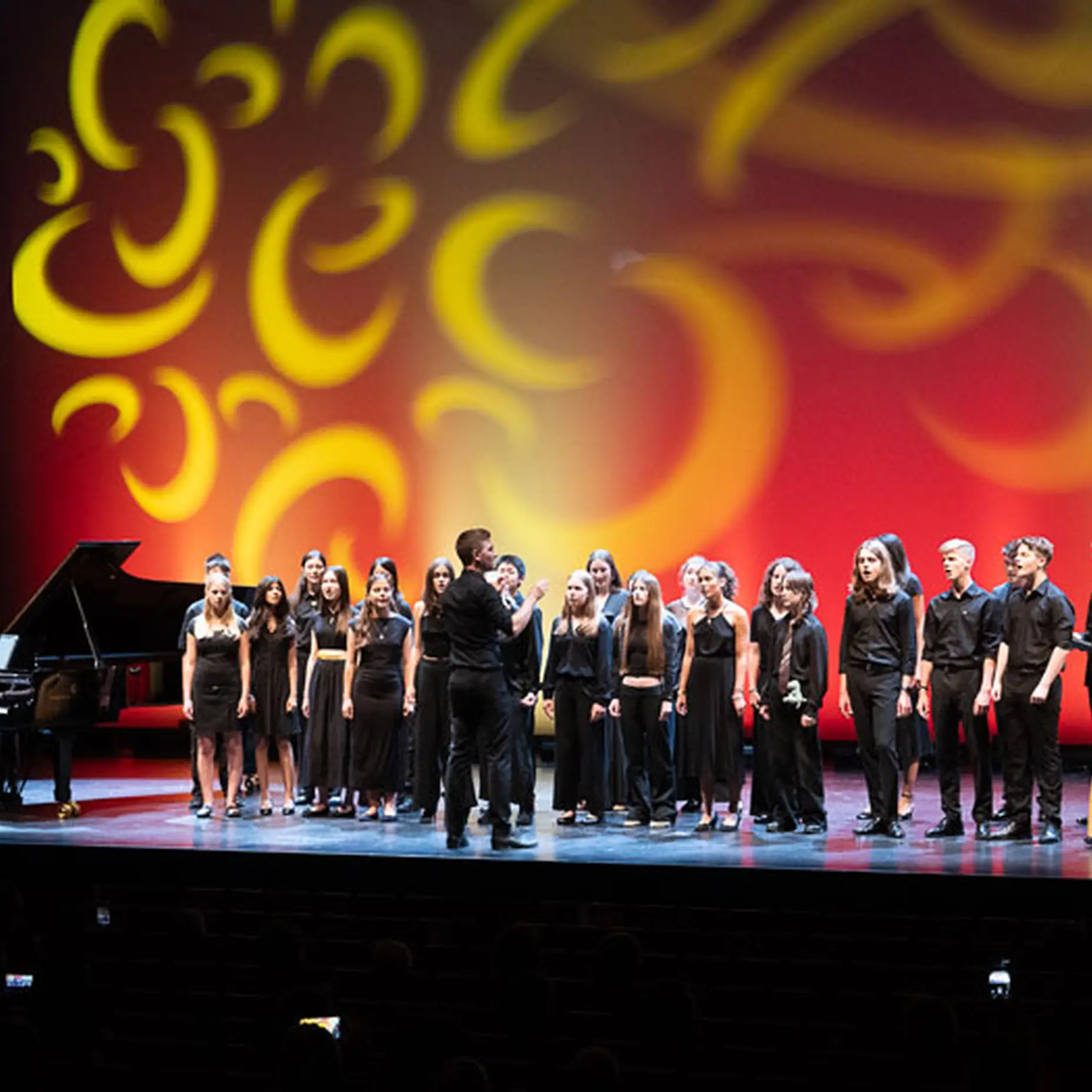 Die Schüler*innen des Projekts IM.PULS stehen auf der Bühne und singen bei dem Abschlusskonzert.