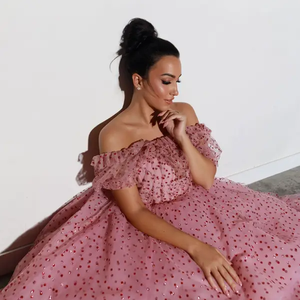 Die Opernsängerin Carolina López Moreno sitzt im ausladenden rosa Kleid auf dem Boden.