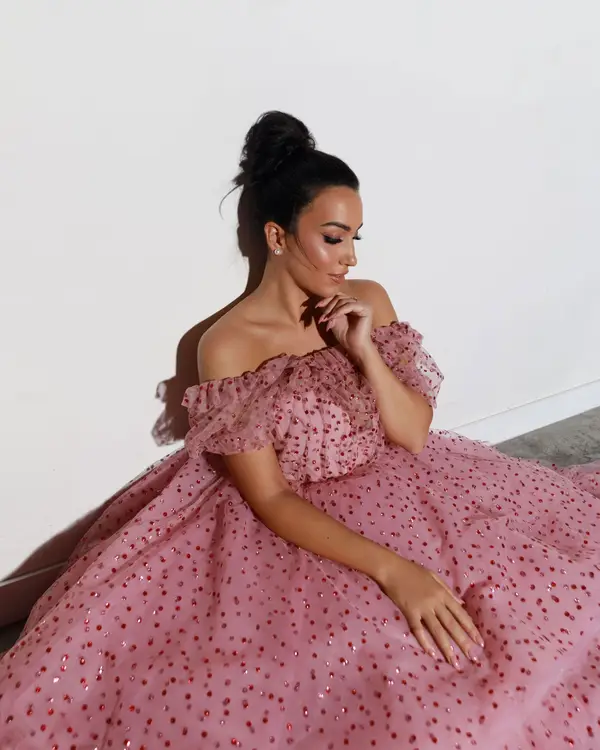 Die Opernsängerin Carolina López Moreno sitzt im ausladenden rosa Kleid auf dem Boden.