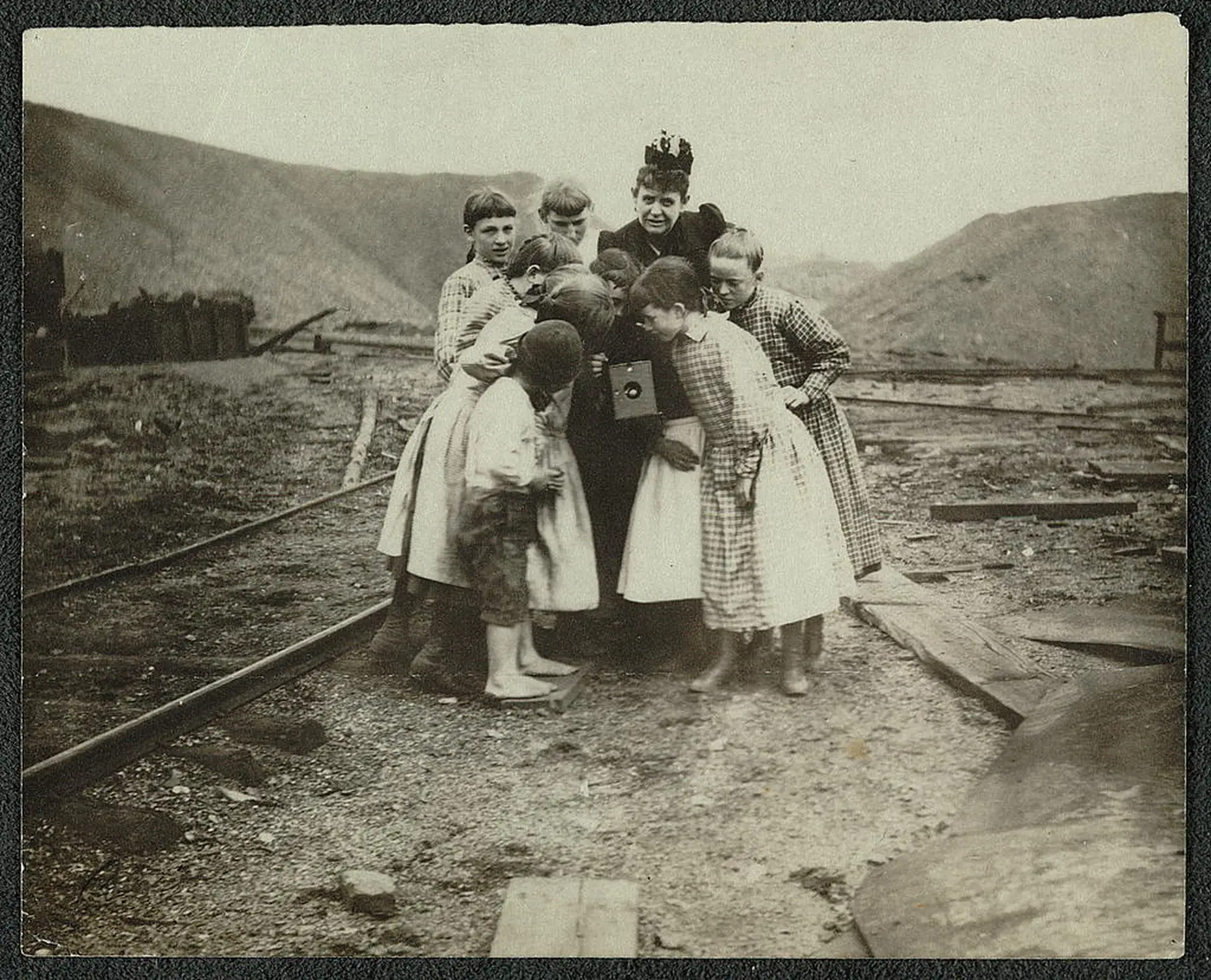 Ein Schwarz-weiß-Bild von vielen Kindern um einen Kodak Rollfilm.