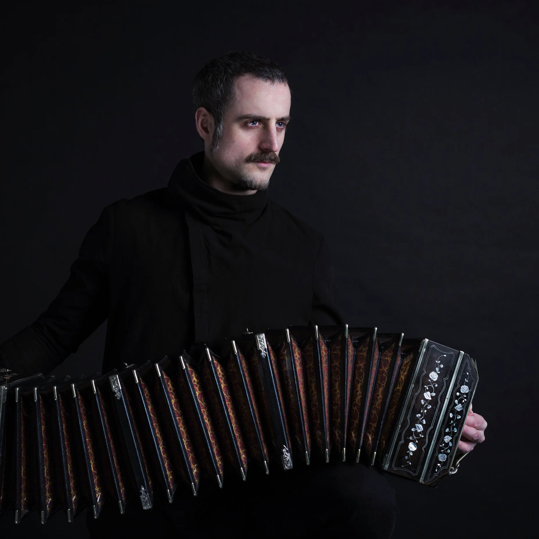 Omar Massa spielt ein Bandoneon in einem dunklen Studio