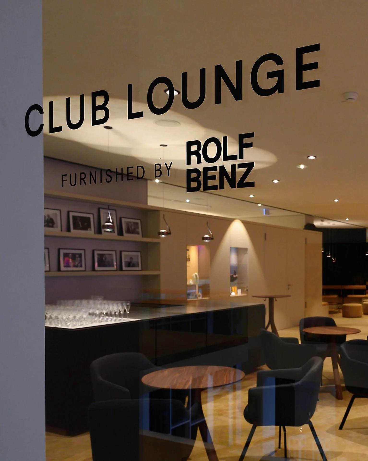Eine stilvolle Club Lounge mit einer eleganten Einrichtung, darunter bequeme Stühle und Tische. Dezente Beleuchtung schafft eine gemütliche Atmosphäre.