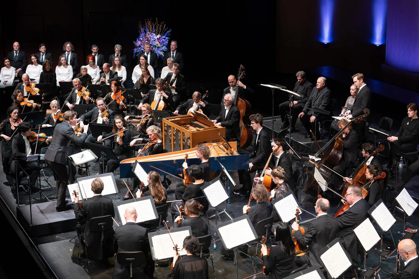 Dirigent dirigiert Orchester als auch Chor und Solistinnen und Solisten.