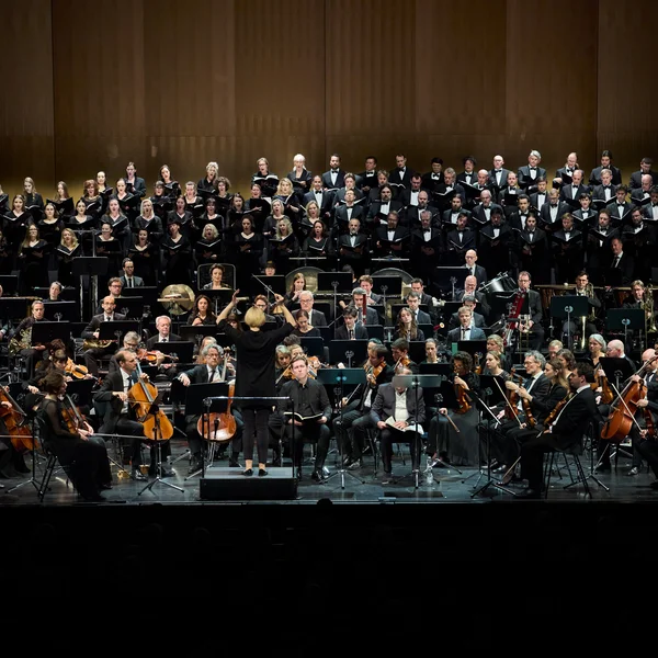 Dirigentin leitet Orchester und Solisten.