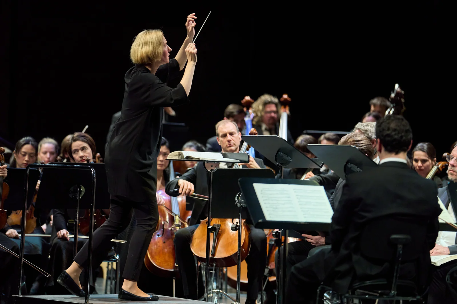 Dirigentin dirigiert leidenschaftlich das Orchster.