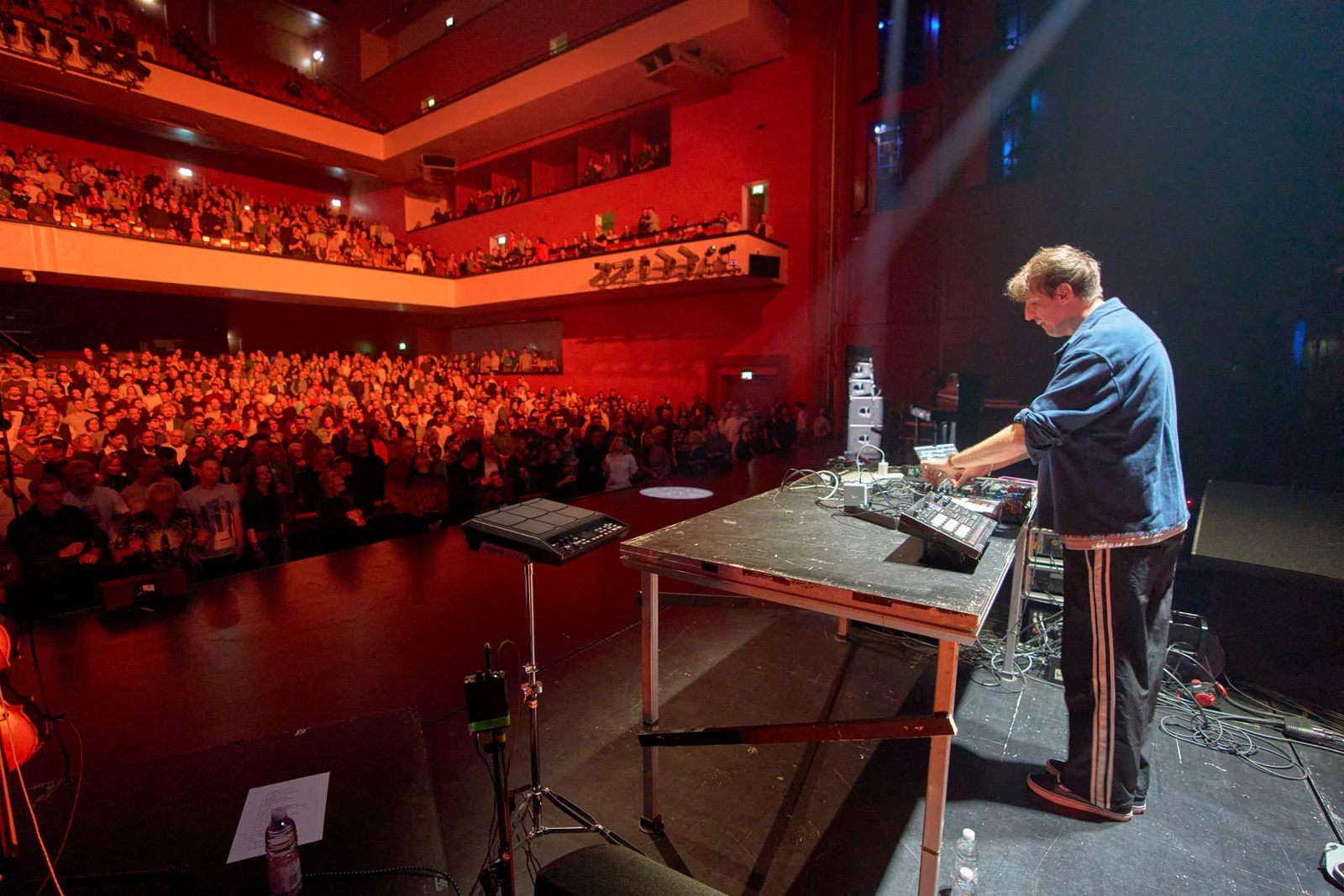 DJ auf der Bühne mit Sicht in den Saal und auf das Publikum.