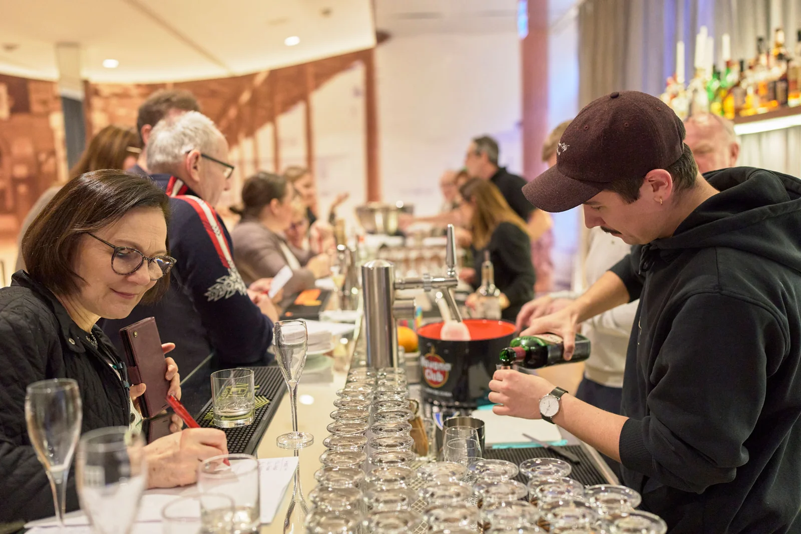 Bar, an der ein Drink in ein Glas gefüllt wird bei einem Cocktail-Workshop.